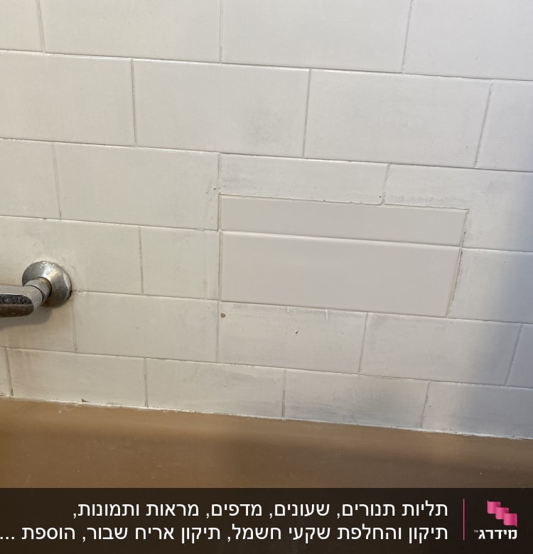 ברז מתכת על קיר אריחים לבנים